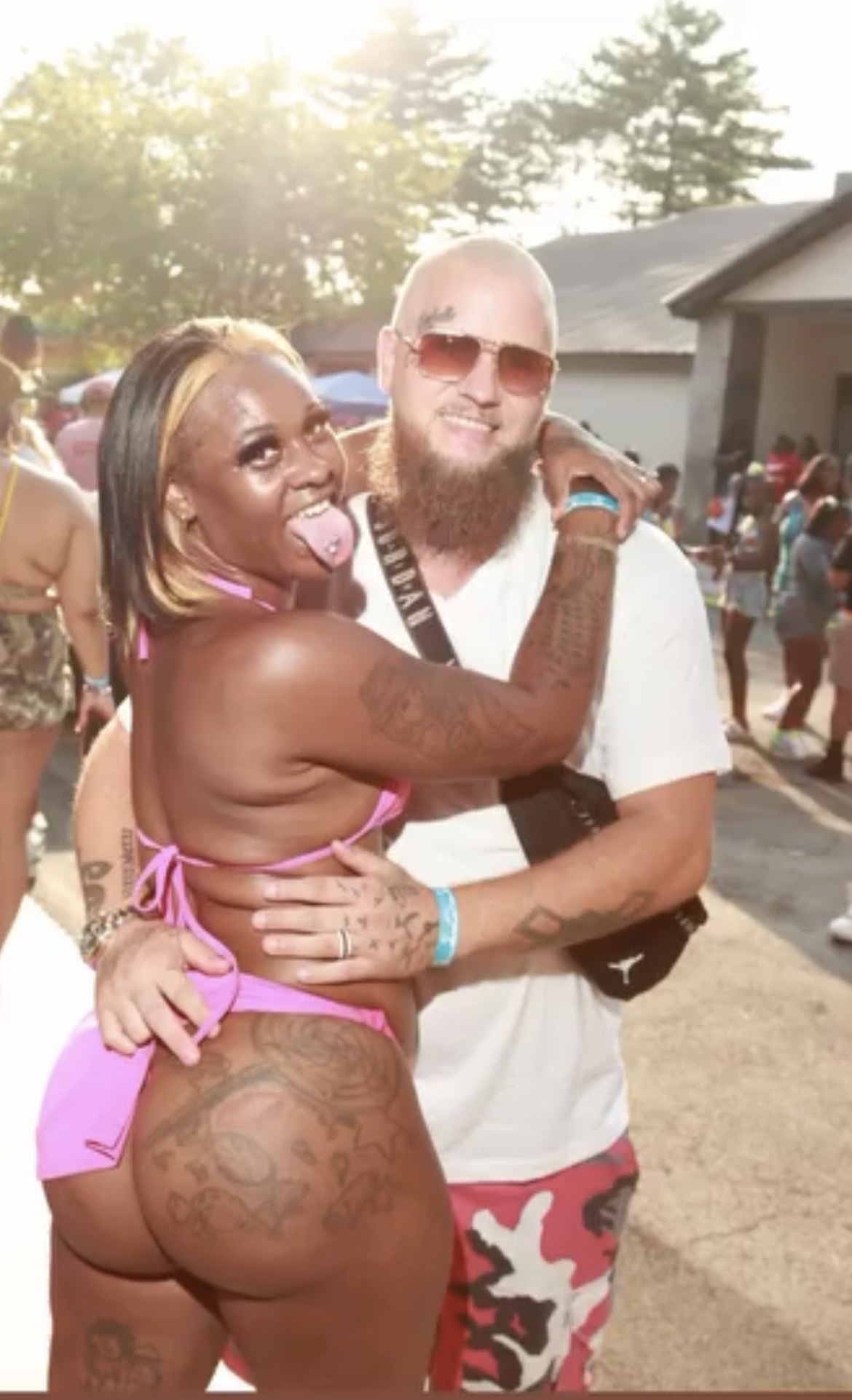 Two artists photographed together in the sun at a festival day party