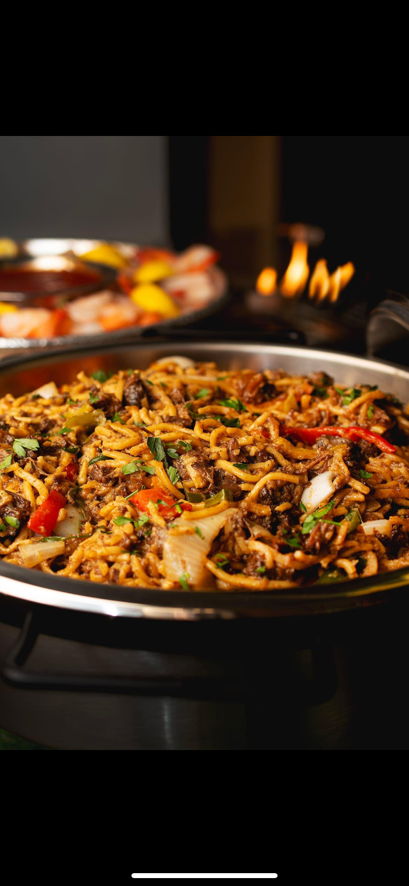 Noodle stir-fry photographed in the pan at the table