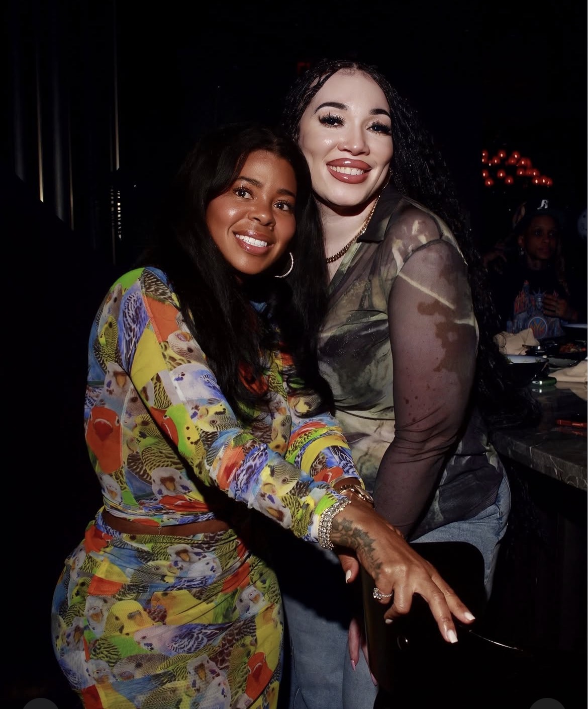 Two guests photographed together at a night venue