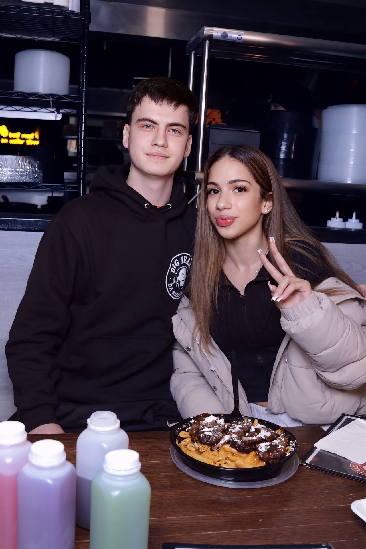 Couple photographed at the counter with a skillet pasta in front of them