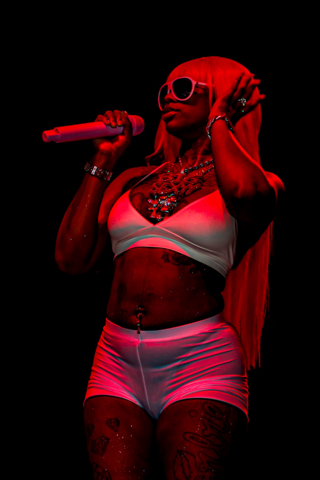 Female performer singing onstage under dramatic red lighting