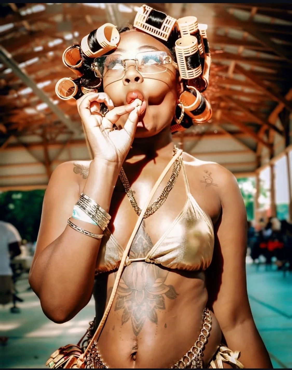 Styled editorial portrait with gold hair rollers